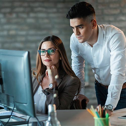 HR manager advising a colleague at a workstation