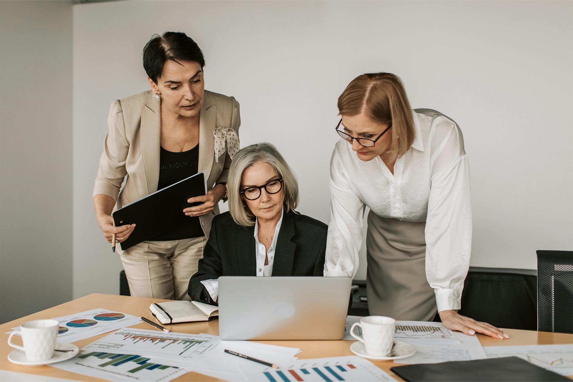A trainer working through German language material with two colleagues